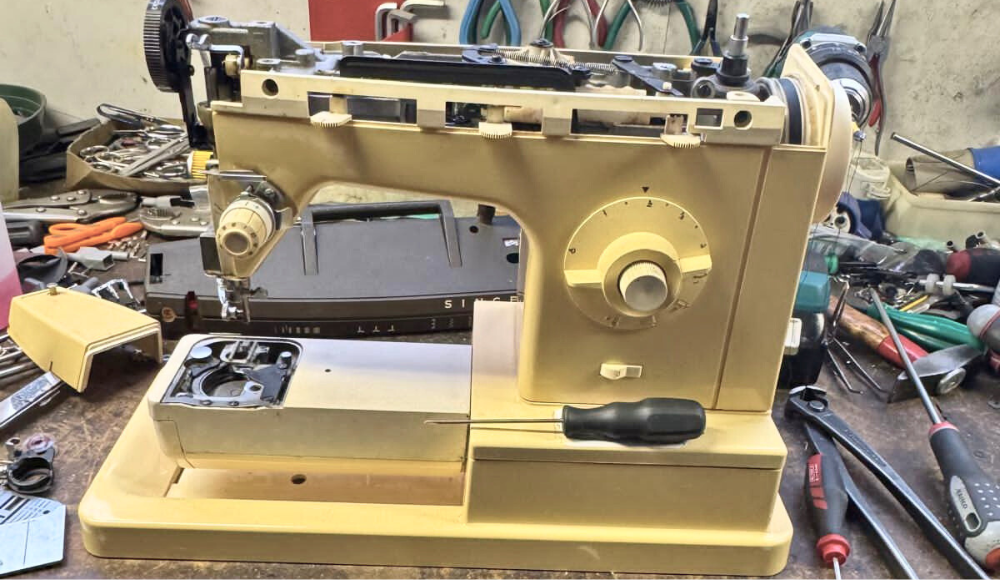 Macchina da cucire smontata sul banco di lavoro per una revisione